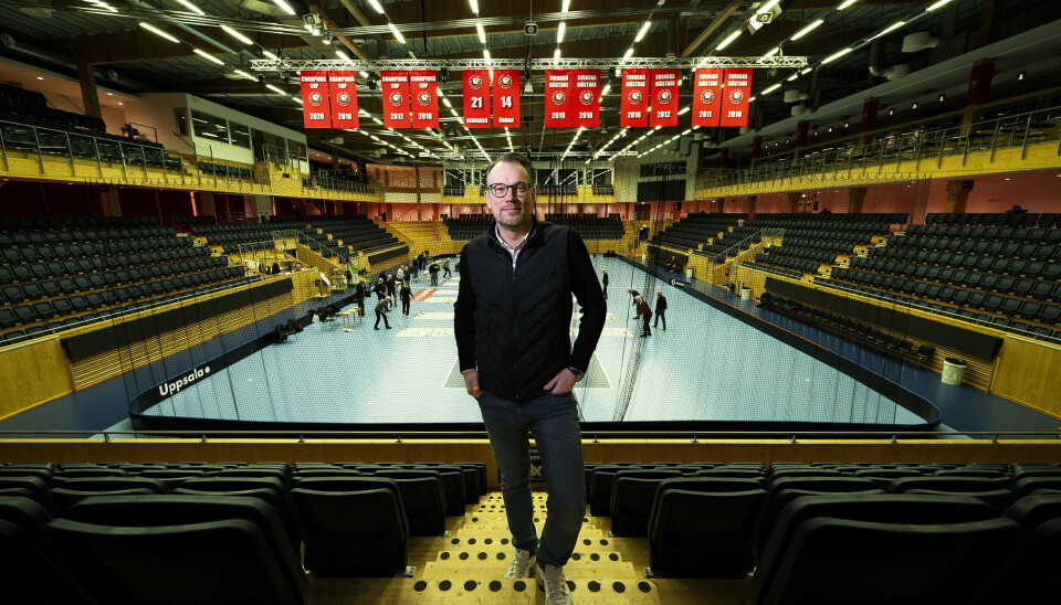 Person i väst står i arenans läktartrappor framför mästerskapsvepor